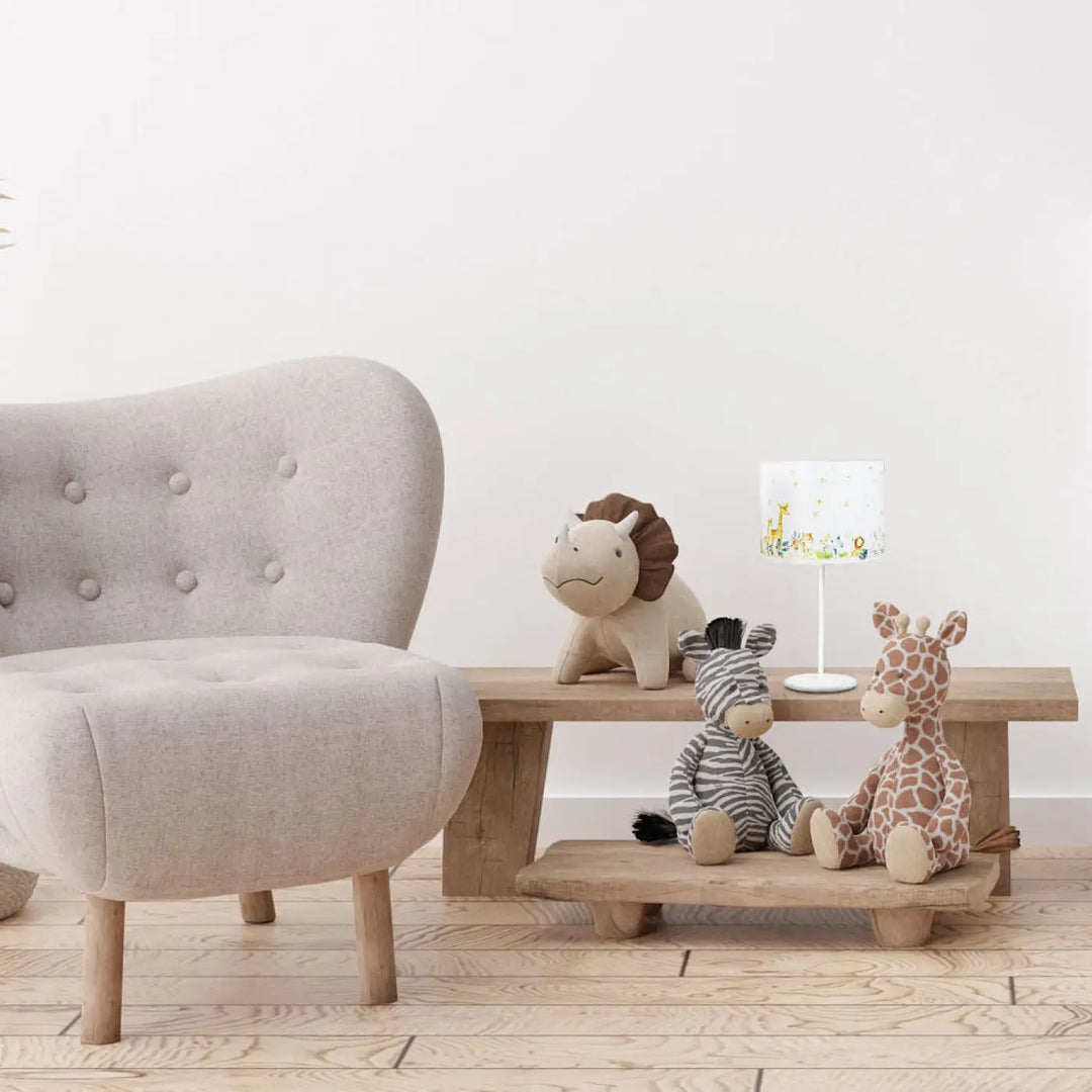 Lampe de table sweet dreams jaune aux animaux avec lumière douce à côté d’un fauteuil beige tufté aux pieds en bois