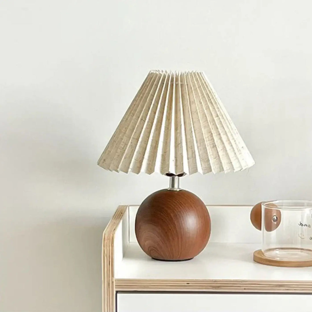 Lampe de chevet avec abat-jour plissé crème sur socle sphérique en bois pour une lumière douce et décoration intérieure élégante