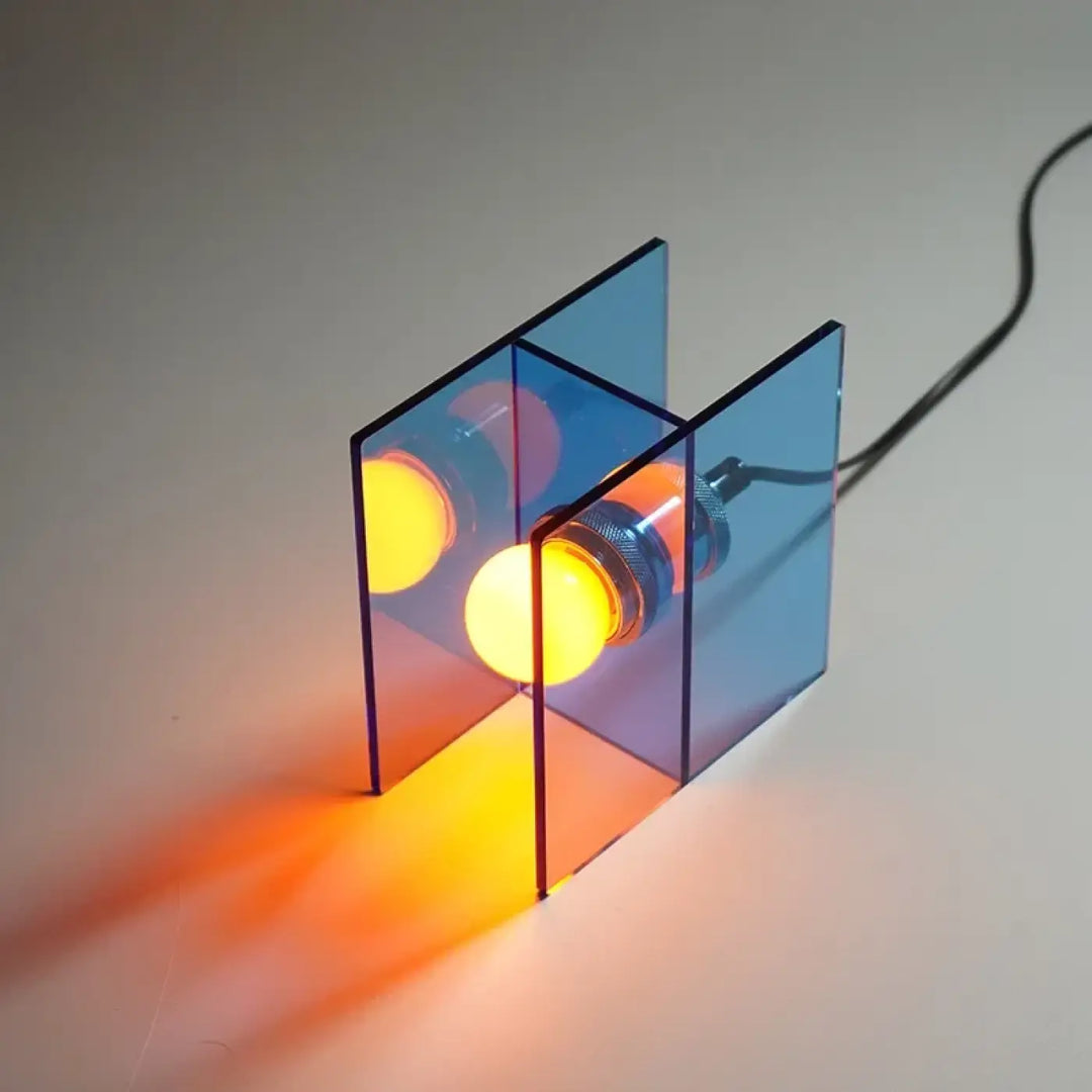 Lampe de chevet anura cube acrylique bleu translucide avec trois ampoules orange pour une lumière douce et esthétique contemporaine