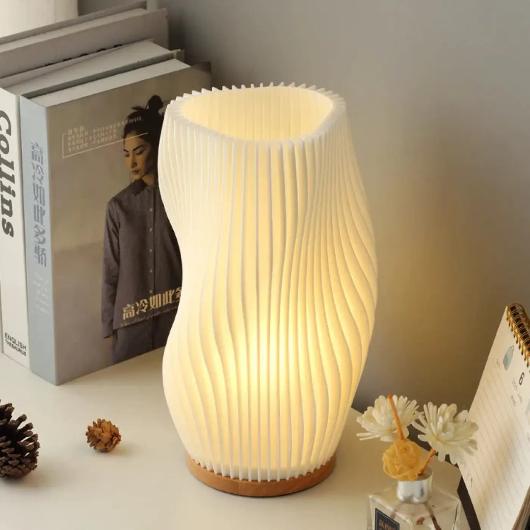 Lampe de table loana avec corps blanc sculpté à lignes fluides et base en bois pour une ambiance chaleureuse