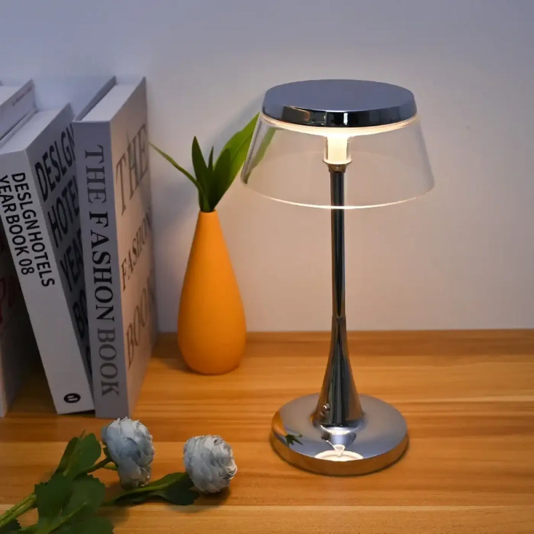 Lampe de table tiah avec design chrome, base et tige chromées, abat-jour transparent diffusant une lumière chaude led