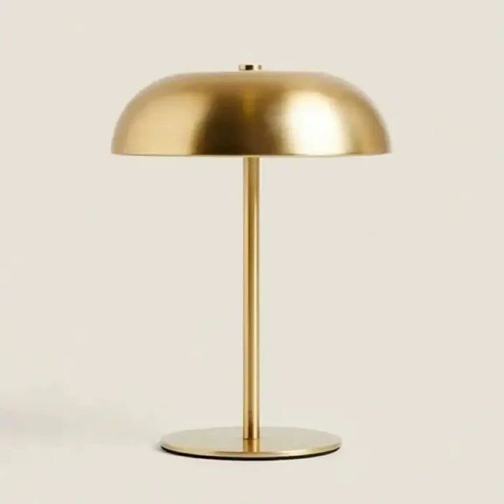 Lampe de table kapel finition dorée avec silhouette minimaliste et détail participe en métal moderne