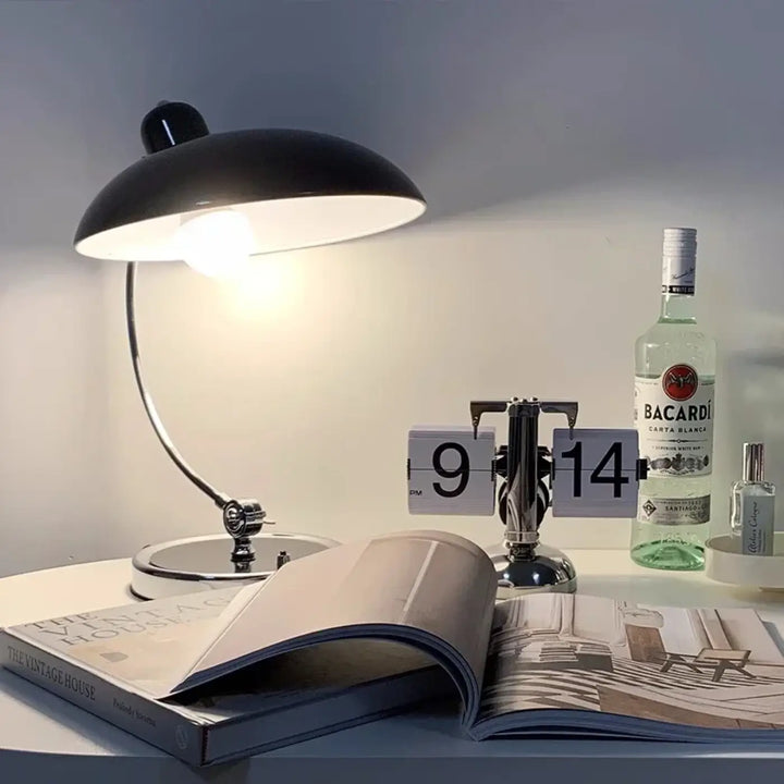 Lampe de table arcane noire en métal avec bras courbé et abat-jour intérieur blanc pour table moderne