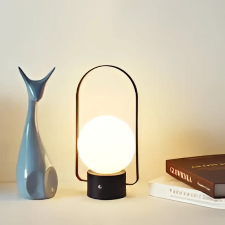 Lampe de table archelia avec sphère lumineuse en verre blanc et arche métallique élégante noire minimaliste