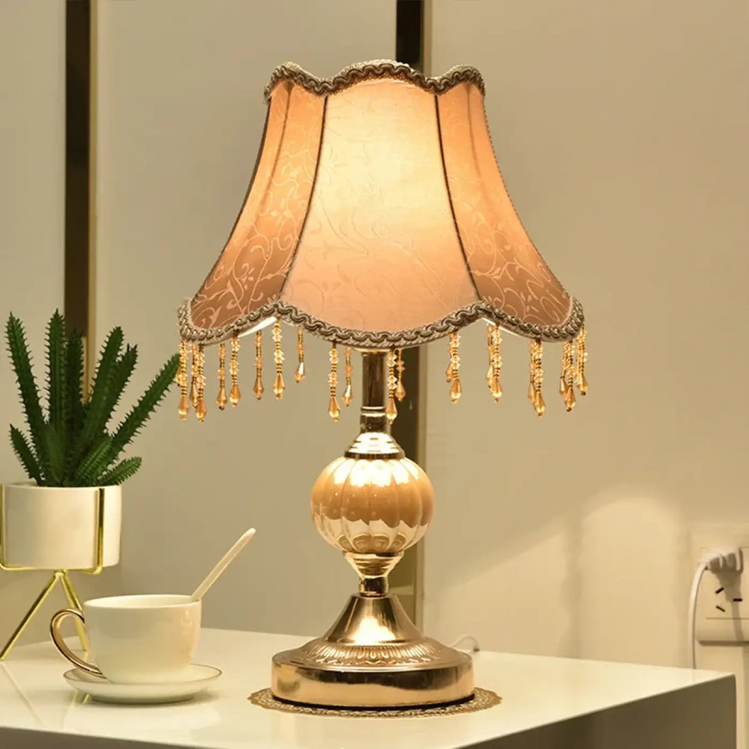 Lampe de table debhy en ton dor avec abat-jour en tissu pêche orné de franges en cristal pour décoration intérieure vintage chic