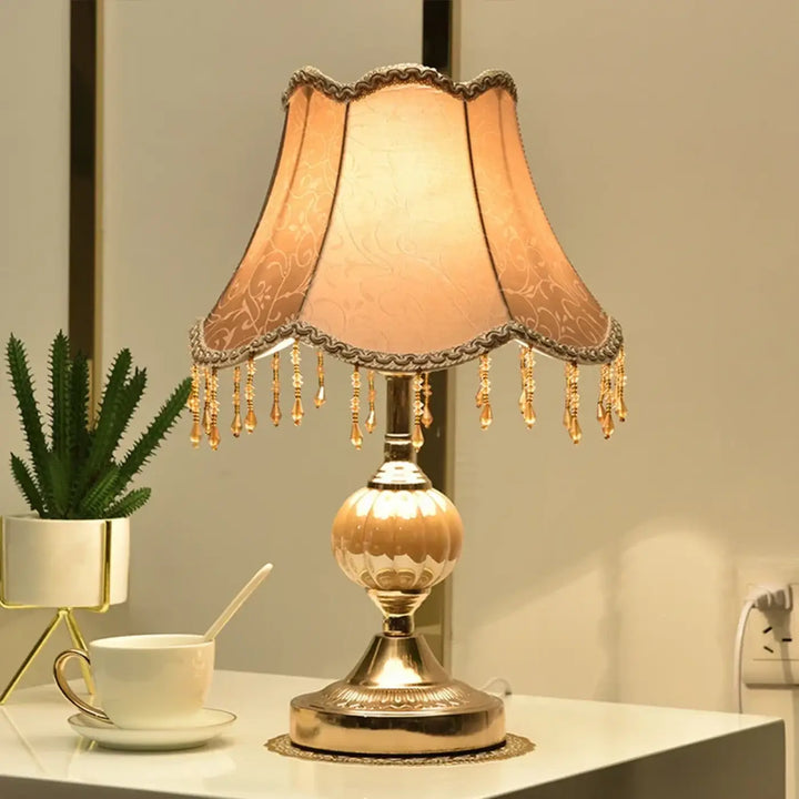 Lampe de table debhy en ton dor avec abat-jour en tissu pêche orné de franges en cristal pour décoration intérieure vintage chic