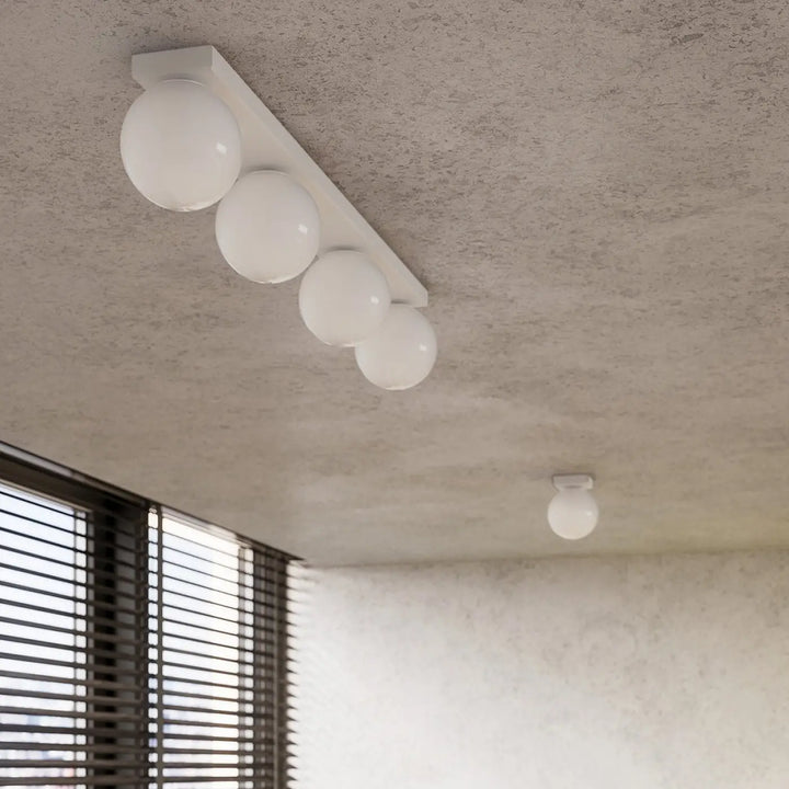 Luminaire plafonnier plafon yoli 2 blanc avec globe sphérique et quatre ampoules sur barre rectangulaire minimaliste classe à part
