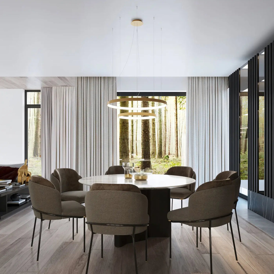 Plafonnier rio moderne en anneaux dorés concentriques avec modules led offrant une efficacité lumineuse élevée au-dessus d’une table à manger