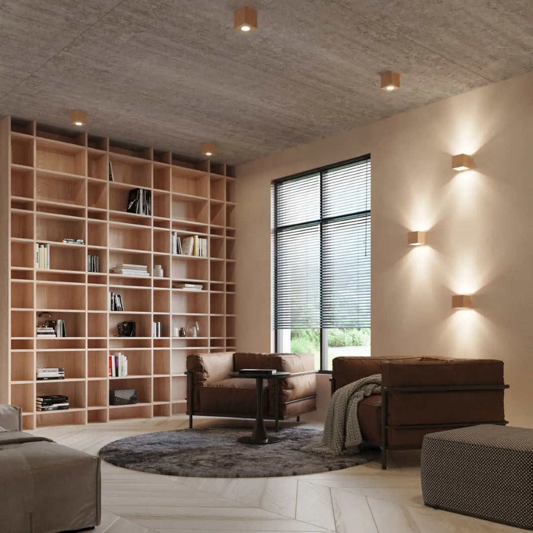 Luminaire plafonnier quad 1 en bois naturel avec ambiance chaleureuse près de fauteuils en cuir brun et couverture texturée