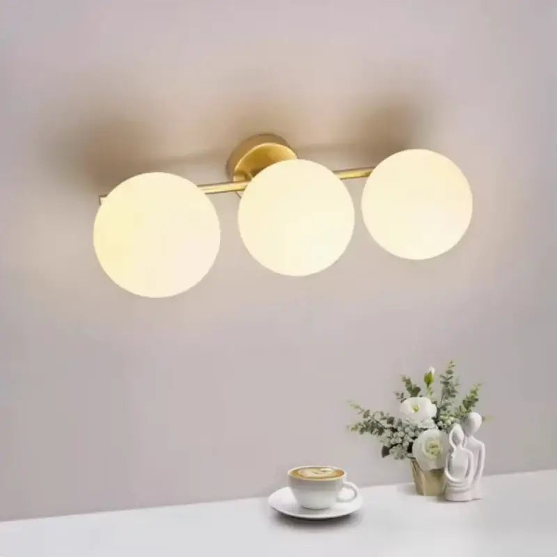 Luminaire plafonnier moderne en boules blanches avec support doré