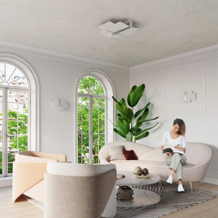 Luminaire plafonnier celia chrome design intemporel avec canapé blanc moderne aux lignes courbes et finition douce