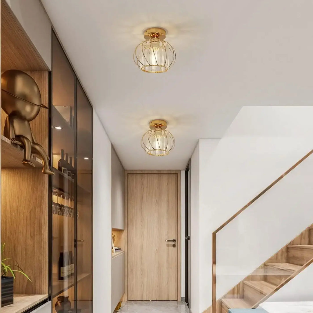 Luminaire plafonnier veloria en cage dorée avec globe en cristal transparent et lumière diffuse chaleureuse