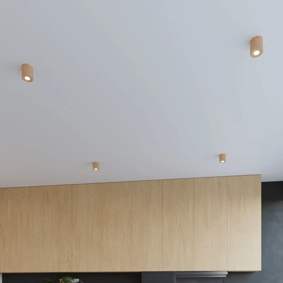 Luminaire plafonnier orbis bois naturel avec trois spots cylindriques montées individuellement ambiance chaleureuse