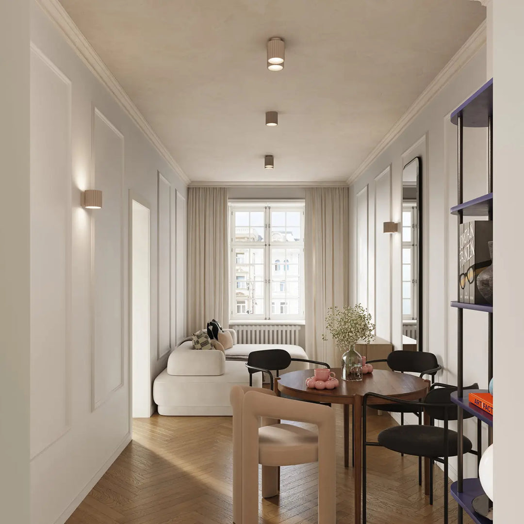 Luminaire plafonnier aura 1 taupe avec forme unique inspirée au-dessus d’une table ronde en bois avec chaises noires