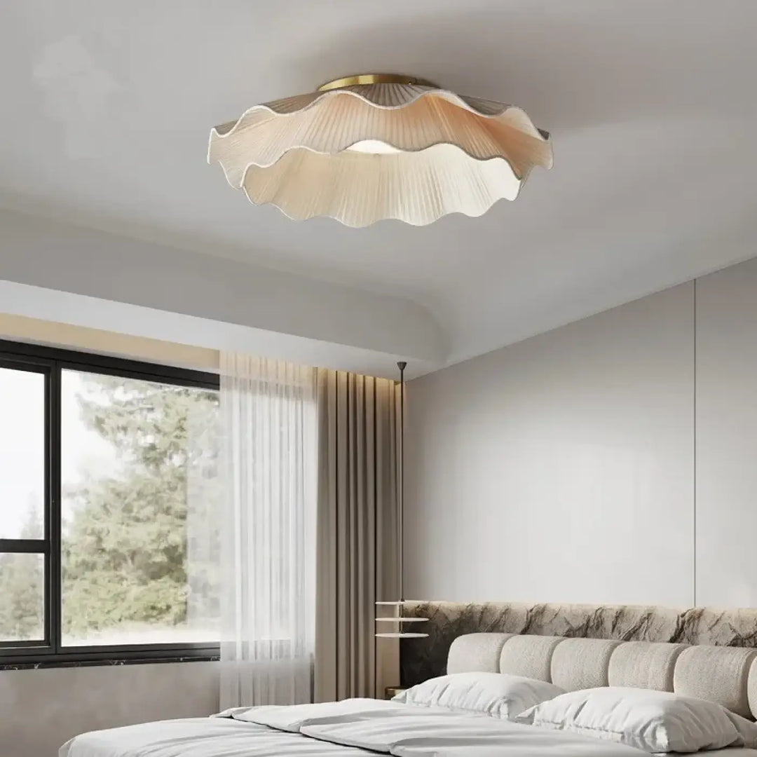 Luminaire plafonnier contemporaine en tissu plissé beige avec bordure métal doré offrant une lumière enveloppante