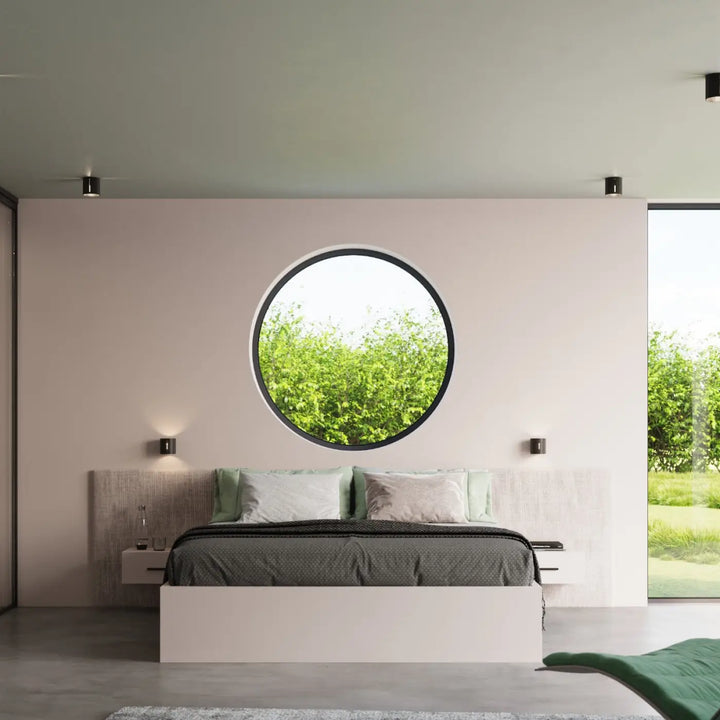 Plafonnier inez noir avec cadre circulaire et perforation linéaire pour un spectacle lumineux sur mur rose pâle