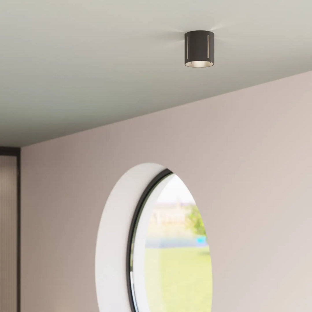 Plafonnier inez noir cylindrique moderne avec perforation linéaire offrant un spectacle lumineux minimaliste