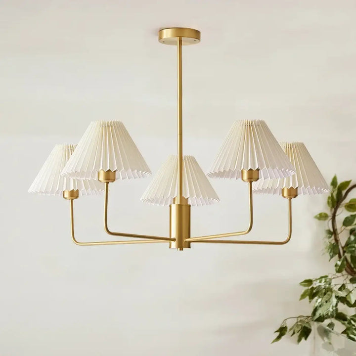Suspension luminaire sandrya en ton or avec cinq abat-jour en tissu plissé blanc idéal pour salle à manger