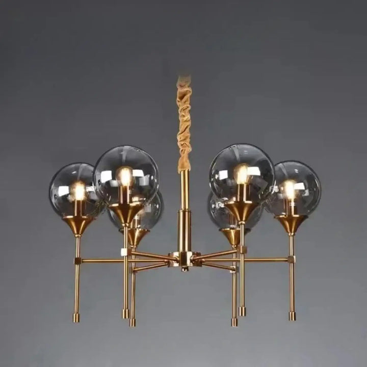 Suspension luminaire bublor en finition laiton avec cinq globes en verre clair et tige torsadée en tissu pour éviter frais supplémentaires