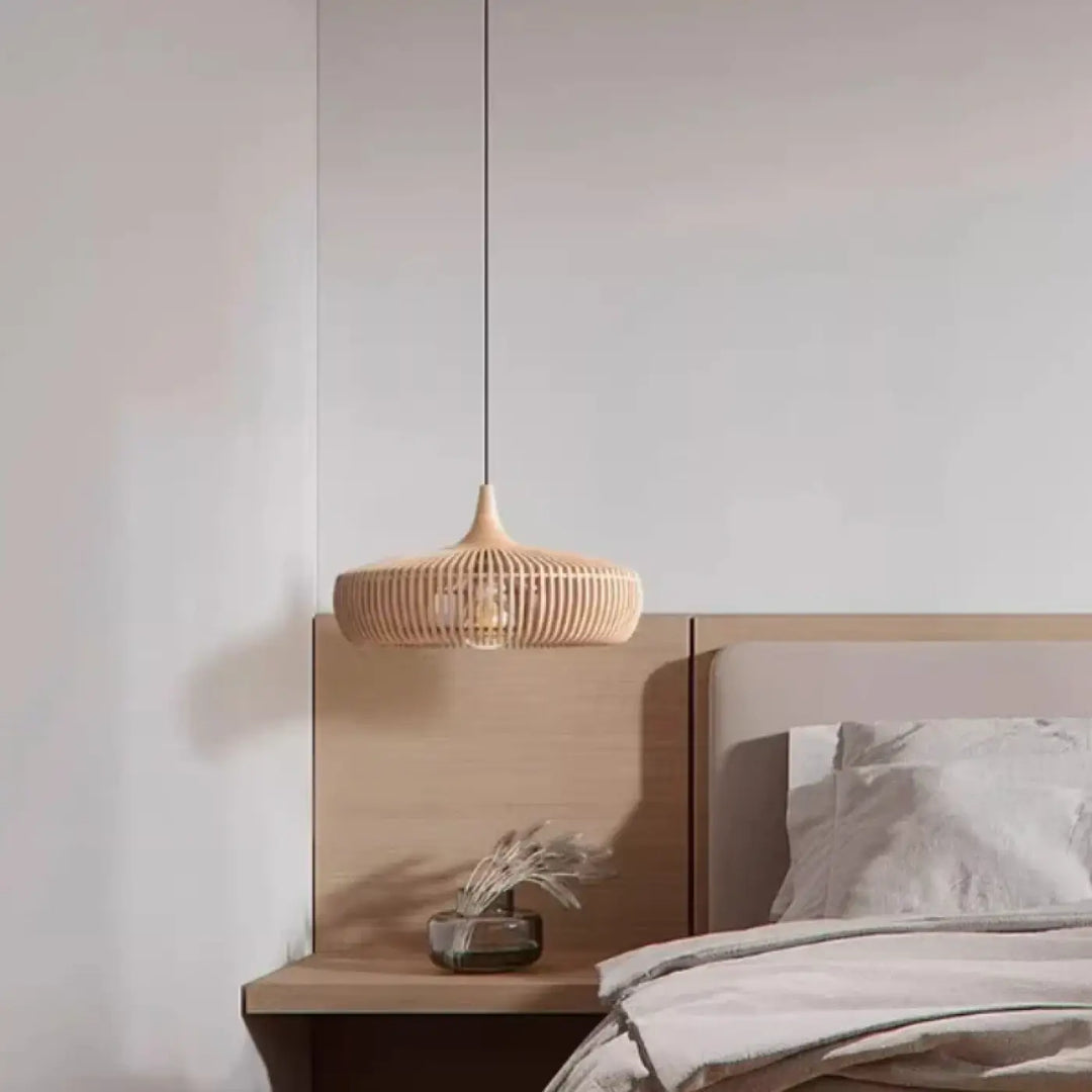 Suspension luminaire andilah en rotin tressé beige naturel suspendue au-dessus d’une table de chevet