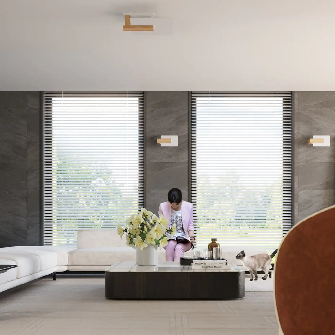 Un vase en céramique blanc avec un bouquet de fleurs jaunes sur une table noire près d un lustre lappo en bois naturel design intemporel
