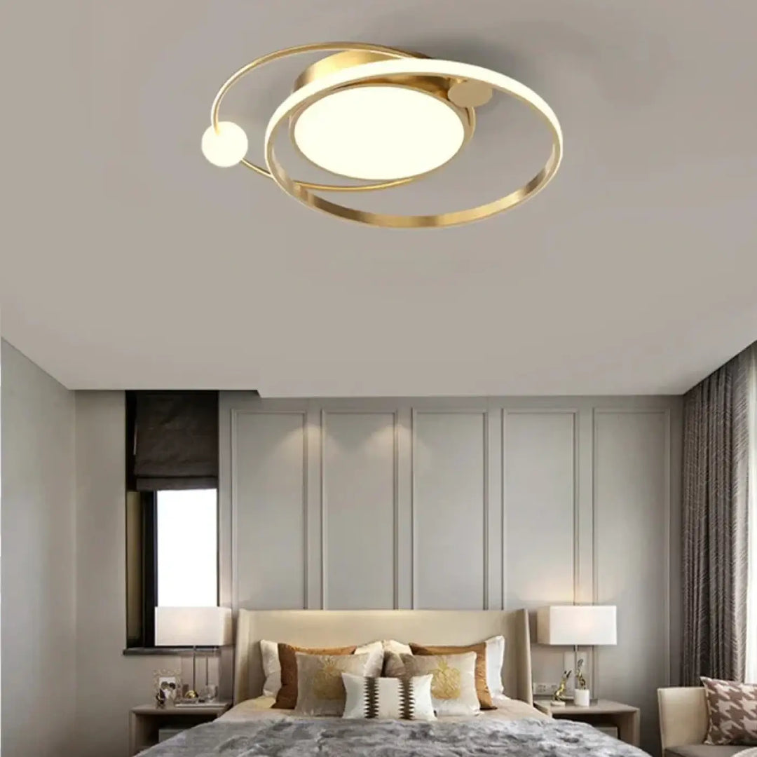 Luminaire plafonnier aloïs en métal doré avec anneaux concentriques et disque central pour lumière blanche ou chaude en salle à manger