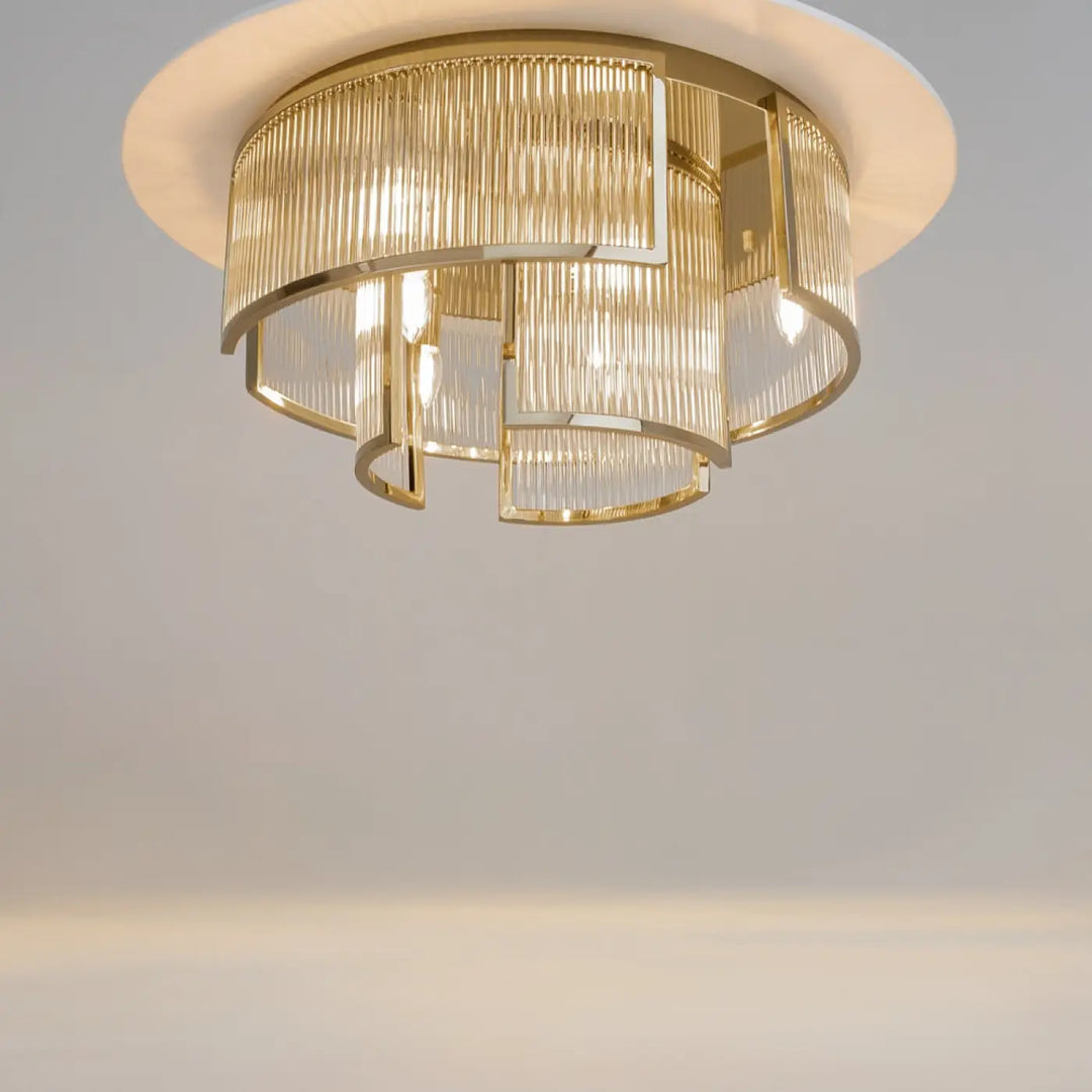 Luminaire plafonnier frame art déco en métal doré avec tiges de verre cylindriques superposées pour un éclairage moderne