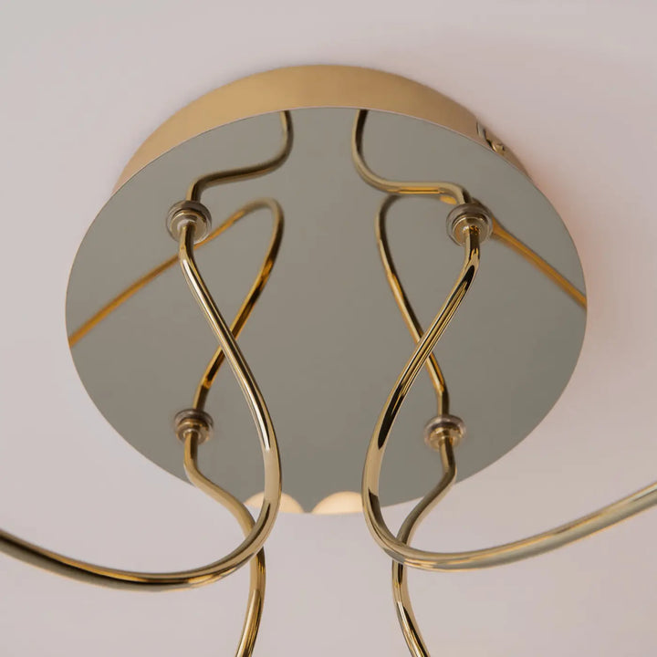 Plafonnier tessara led disque doré en métal doré avec bras courbés et base circulaire miroir élégant
