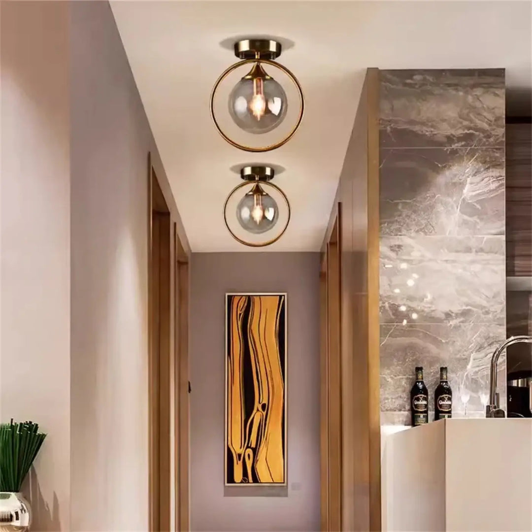 Luminaire plafonnier celliah avec deux cadres circulaires en laiton et globes en verre clair modernes