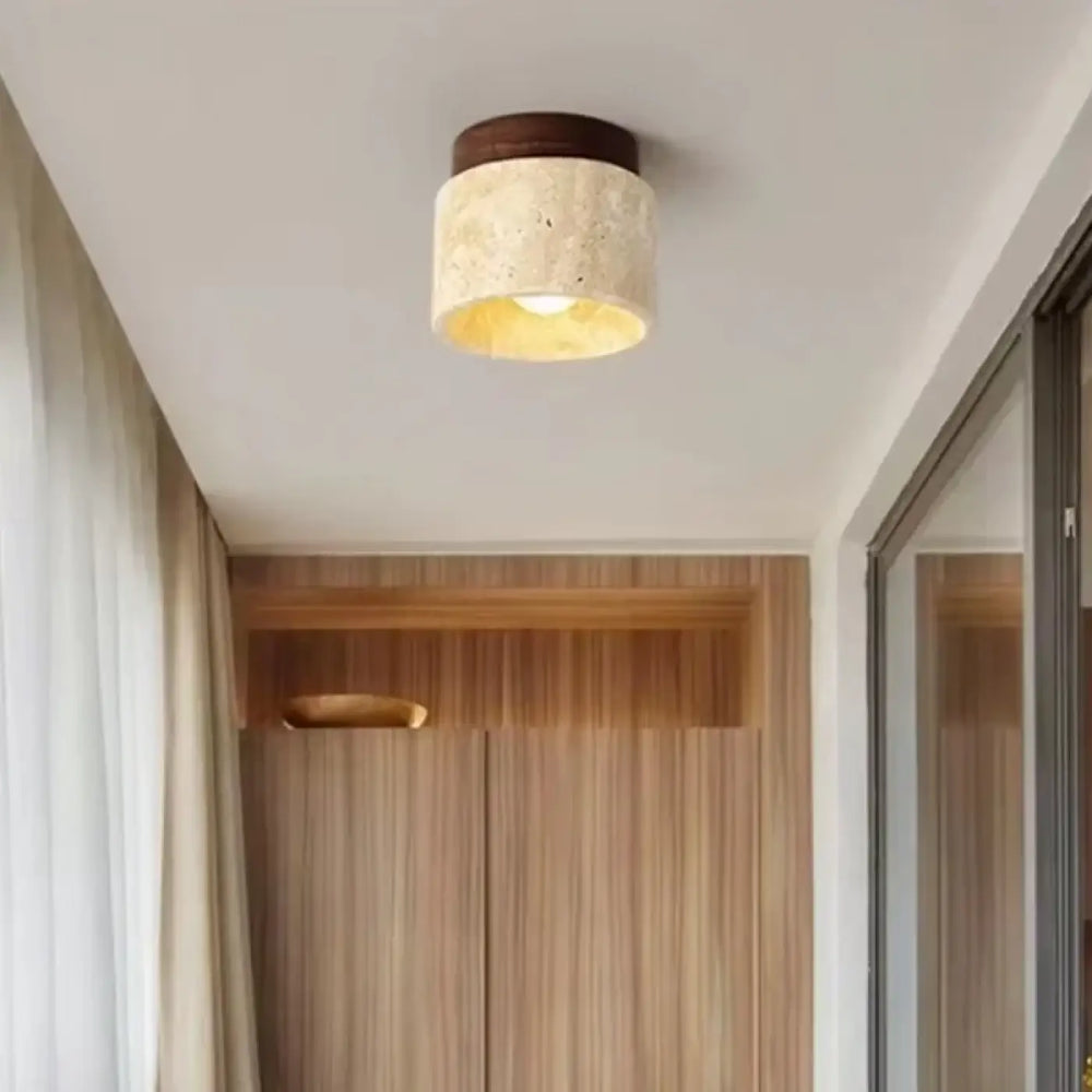 Luminaire plafonnier terris cylindrique avec abat-jour en tissu texturé crème et base en bois foncé émettant une lumière chaude