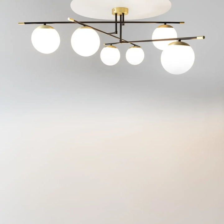 Luminaire plafonnier nostalgia xxl avec six globes en verre dépoli suspendus à une structure noire et dorée