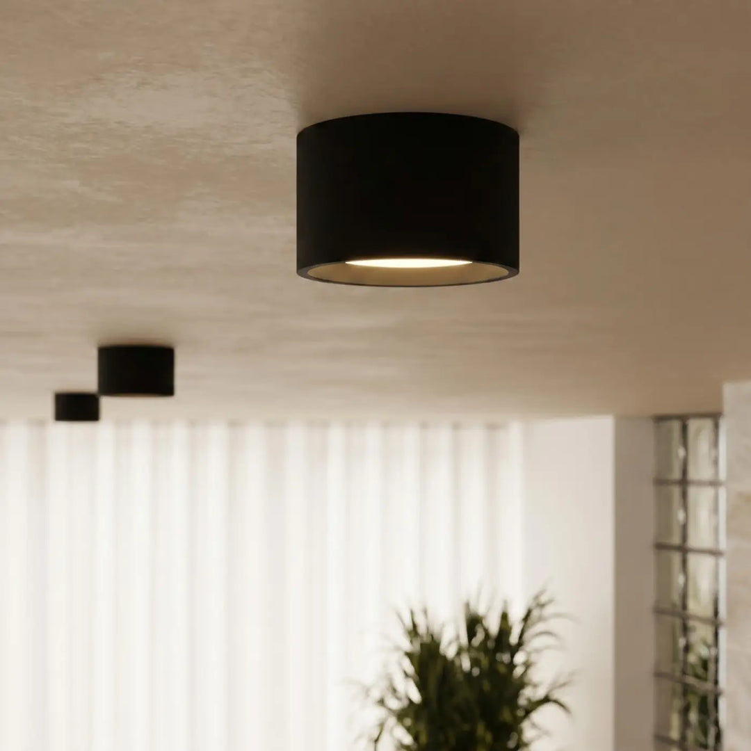 Plafonnier rond plat noir allumé, vue rapprochée