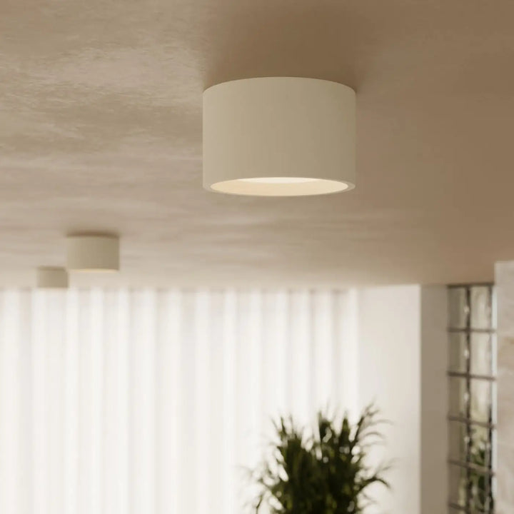 Plafonnier rond plat beige allumé, vue rapprochée