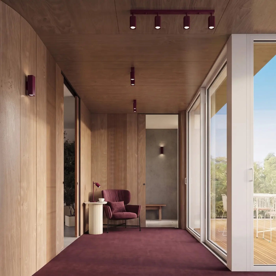 Plafonnier Rayo bordeaux en aluminium cannelé au plafond d'un couloir