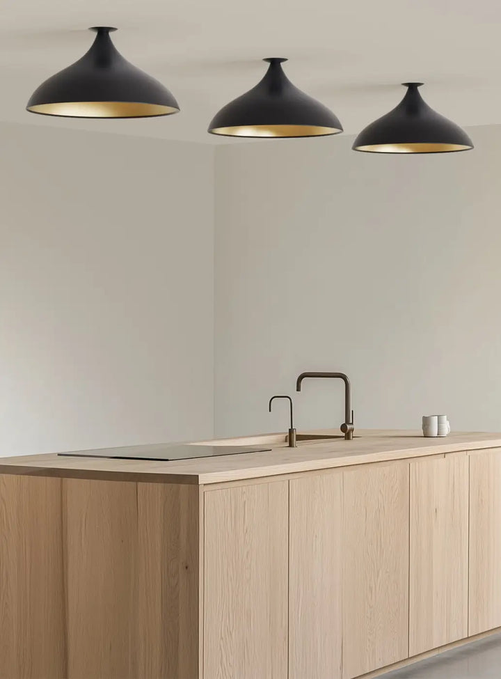 Plafonnier Swell forme large XL, extérieur noir et intérieur laiton dans un intérieur