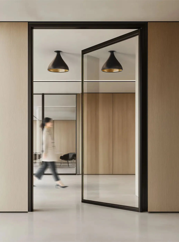 Plafonnier Swell forme moyenne XL, extérieur noir et intérieur laiton dans un intérieur