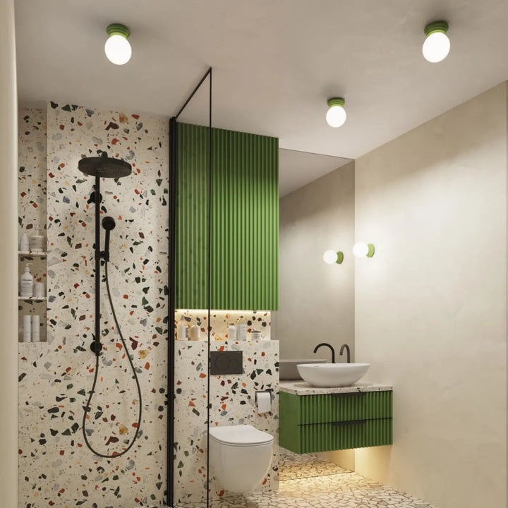 Plafonnier zori vert ip44 dans une salle de bain moderne avec murs en terrazzo et belle décoration en panneaux verts