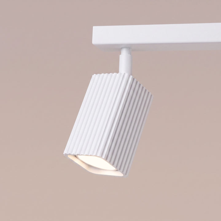 Plafonnier Rayo blanc en rampe à spots orientables, détail des cannelures