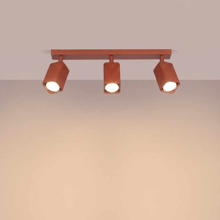 Plafonnier Rayo ocre rouge en rampe à spots orientables, allumé