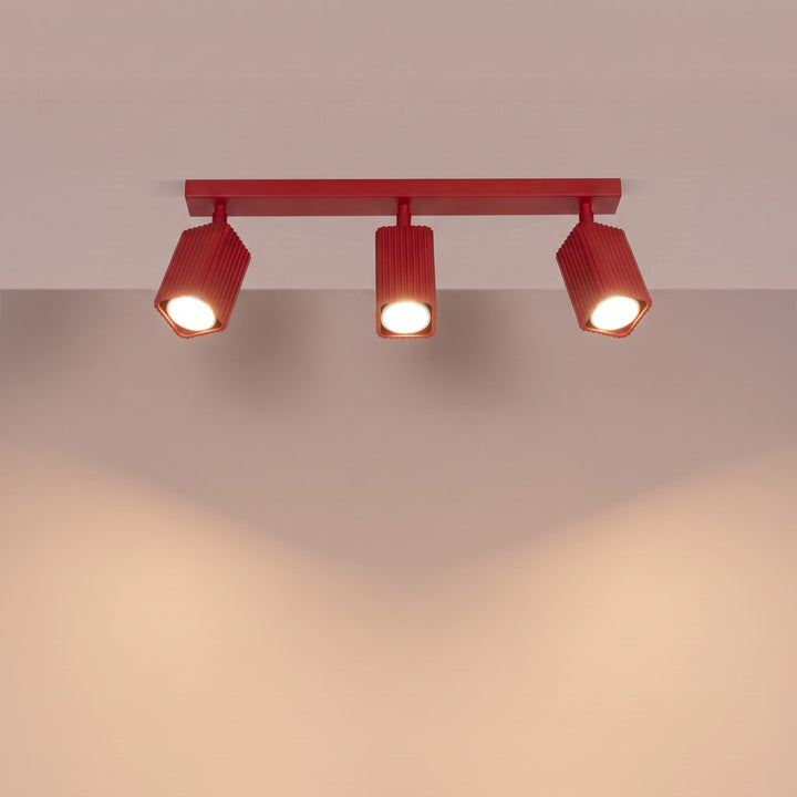 Plafonnier Rayo rouge en rampe à spots orientables, allumé