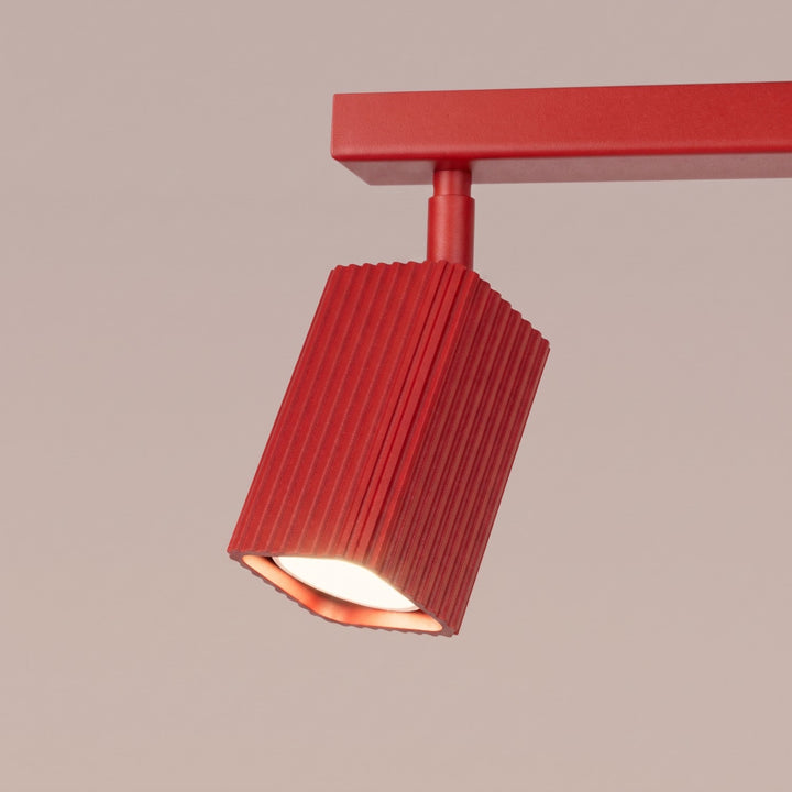 Plafonnier Rayo rouge en rampe à spots orientables, détail des cannelures