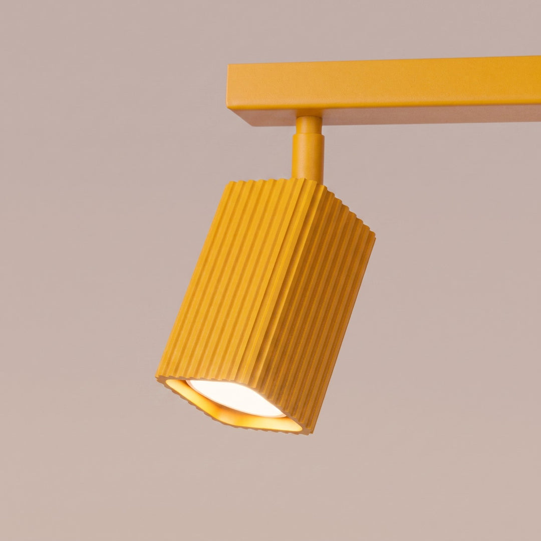 Plafonnier Rayo jaune en rampe à spots orientables, détail des cannelures