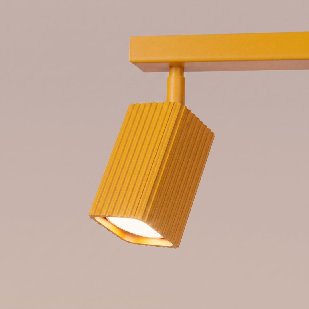 Plafonnier Rayo jaune en rampe à spots orientables, détail des cannelures