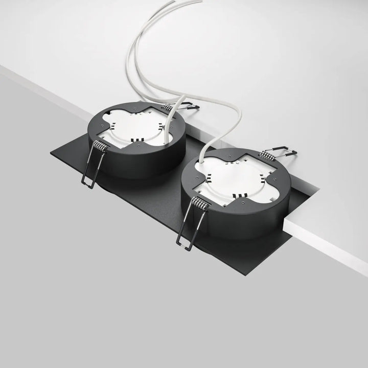 Black circular recessed ceiling spot double lights with white internal hoop double components and attached wiring