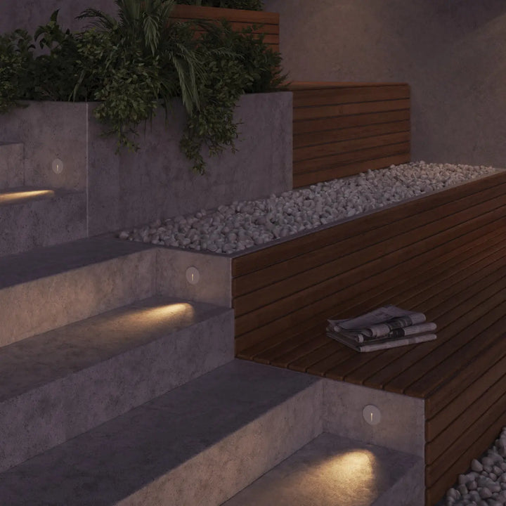 Balise ronde spot encastrable lock led intégrée sur escalier extérieur moderne en béton et bois avec éclairage chaleureux