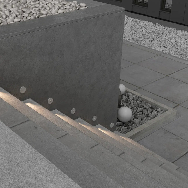 Modern gray concrete balise ronde planter with integrated encastrable lock led lighting and white pebbles