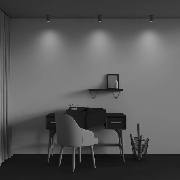Bureau noir minimaliste avec deux tiroirs et pieds fins éclairé par trois finitions d éclairage ciblé spot calipso cylindre cannelé