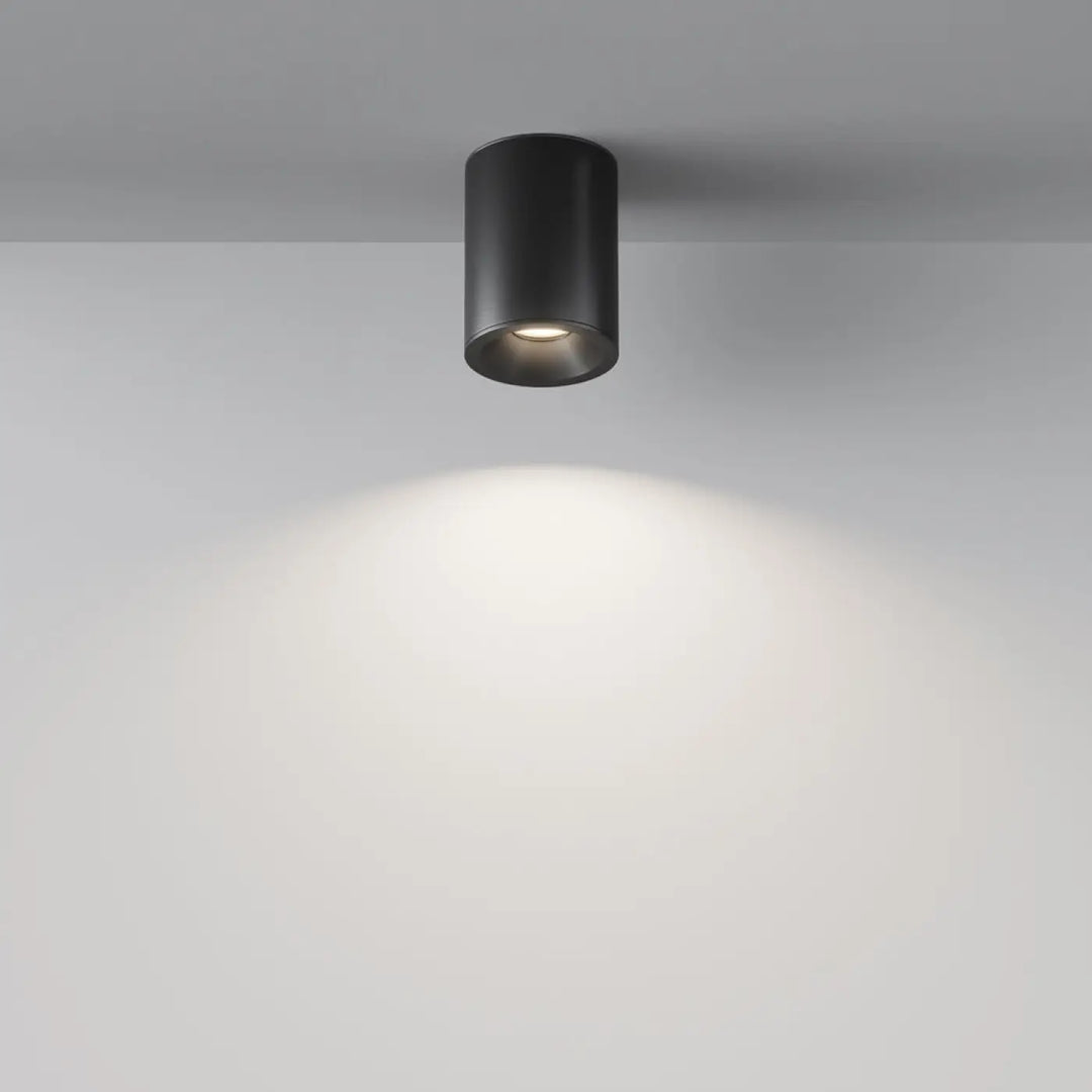 Spot zoom cylindre noir mat encastré au faux plafond avec lumière dirigée chaude et focalisée