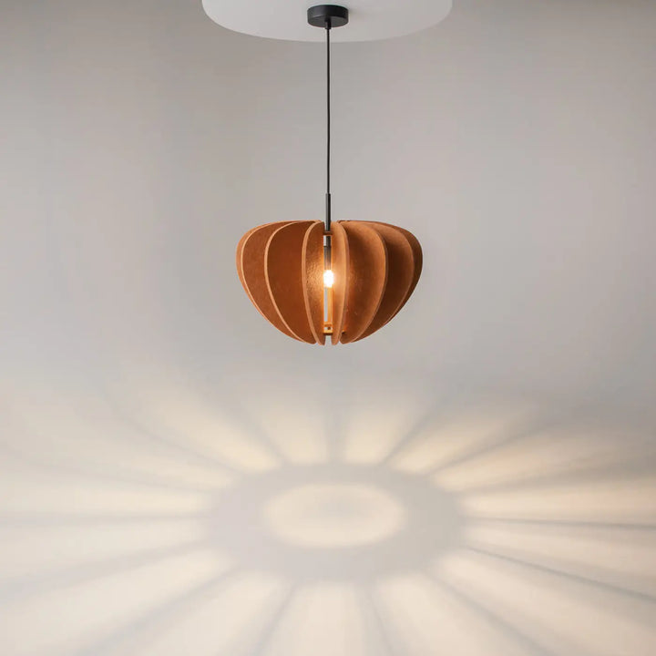 Suspension luminaire cambio coupole en bois segmenté ton chaud avec cordon aluminium noir au-dessus d’une table