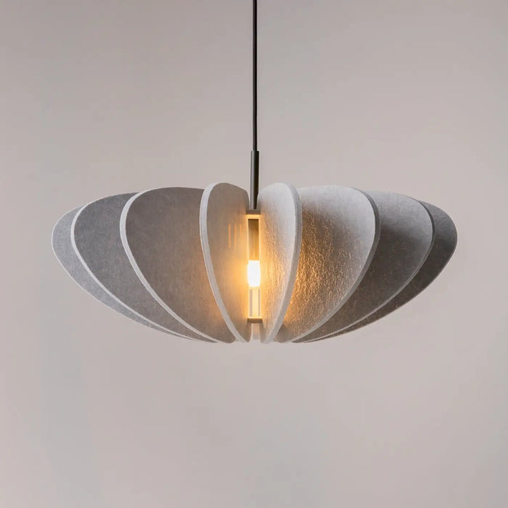 Suspension luminaire cambio avec design en feutre gris texturé et segments circulaires au-dessus d’une table